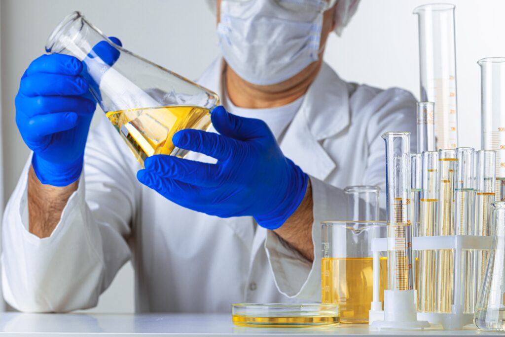 Scientist hands holding some liquid in a glassware in laboratory for analysis
